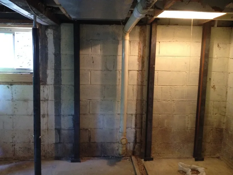 Installed steel beams in basement to brace block walls.