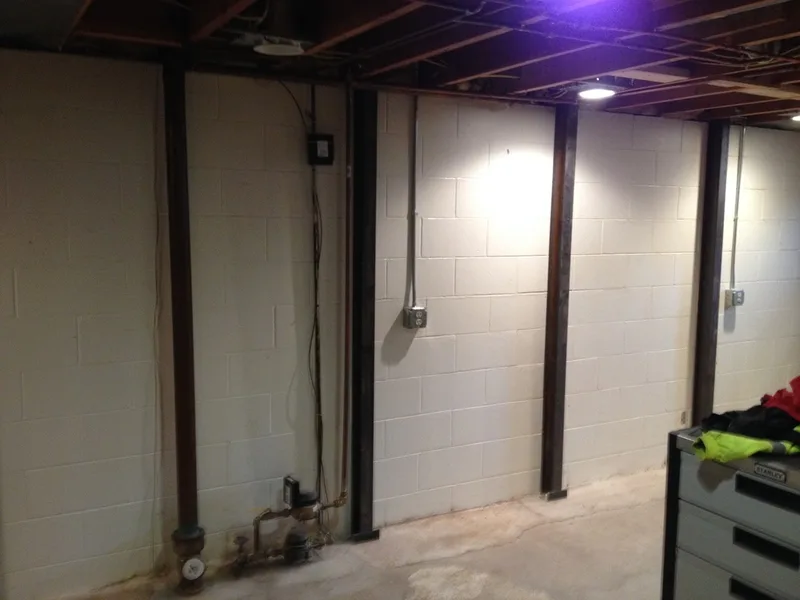 Installed steel beams in basement to brace block walls.